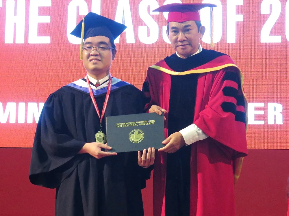 Em Lê Huỳnh Minh Triết nhận bằng tốt nghiệp và chụp hình kỷ niệm với Hiệu trưởng Hồ Thanh Phong tại buổi lễ