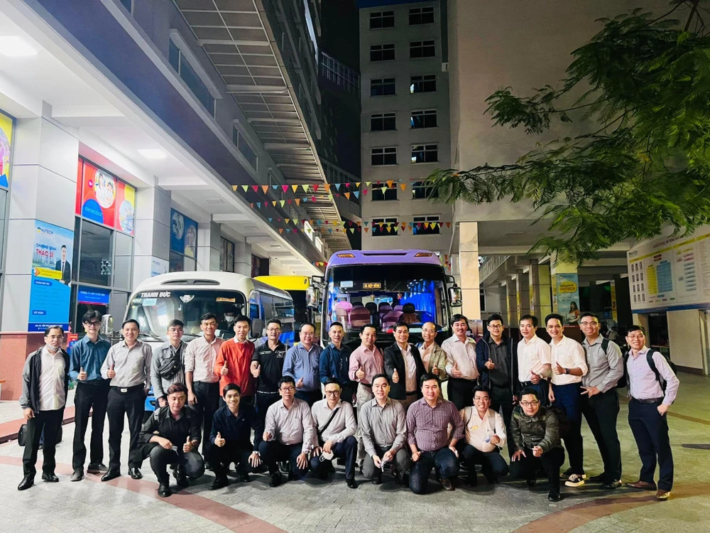 Đoàn công tác của Trường ĐH Công nghệ TP.HCM chụp hình lưu niệm trước khi lên xe khởi hành sáng 6-7.