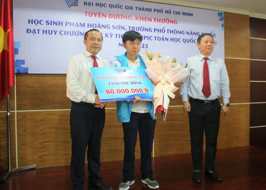 PGS.TS Vũ Hải Quân (bìa trái) và Phó chủ tịch UBND TP.HCM Dương Anh Đức trao hoa, phần thưởng cho em Phạm Hoàng Sơn. Ảnh: P.A