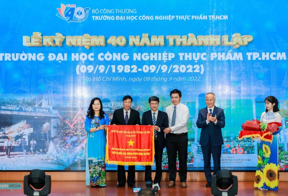 Thứ trưởng Bộ Công thương Trần Quốc Khánh trao Cờ thi đua của Chính phủ cho đại diện tập thể trường. Ảnh: PHẠM ANH