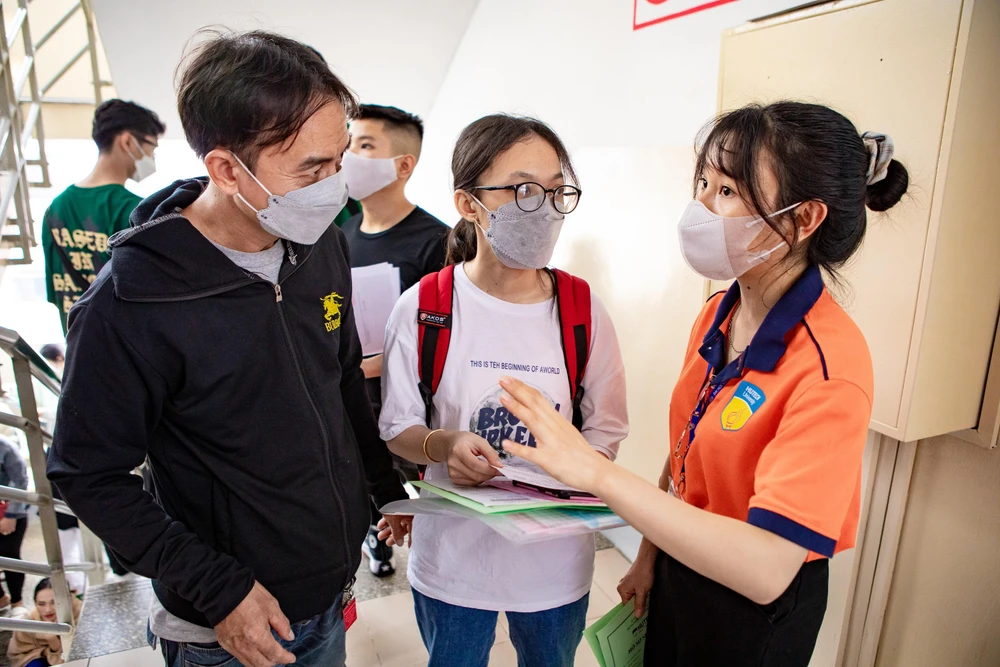 Thí sinh, phụ huynh được các cán bộ hướng dẫn tận tình từng bước làm thủ tục. Ảnh: LÊ GIANG
