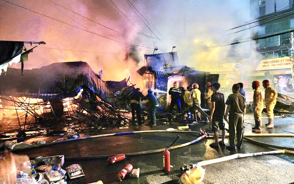 Cảnh sát triển khai công tác dập lửa, ngọn lửa bùng phát nhanh, lan rộng ra nhiều ki-ốt lân cận.