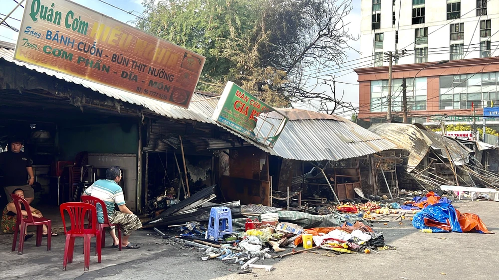 Nhiều tiểu thương ngồi thẫn thờ bên ki-ốt bị cháy.
