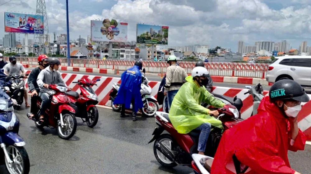 nguoi-di-xe-may-truot-te-hang-loat-tren-cau-sai-gon-do-con-mua-dam-may (1).jpg