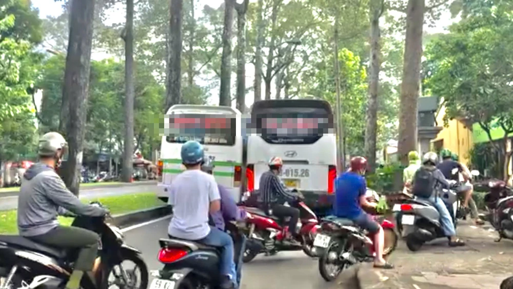 TP.HCM: Hai xe khách di chuyển chắn ngang đường, nhiều xe máy phải chạy lên vỉa hè