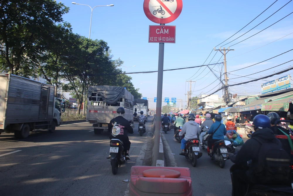 Trước cổng chợ đầu mối Thủ Đức: Làn xe ô tô thành "lối tắt" cho xe máy. Ảnh: PHẠM HẢI