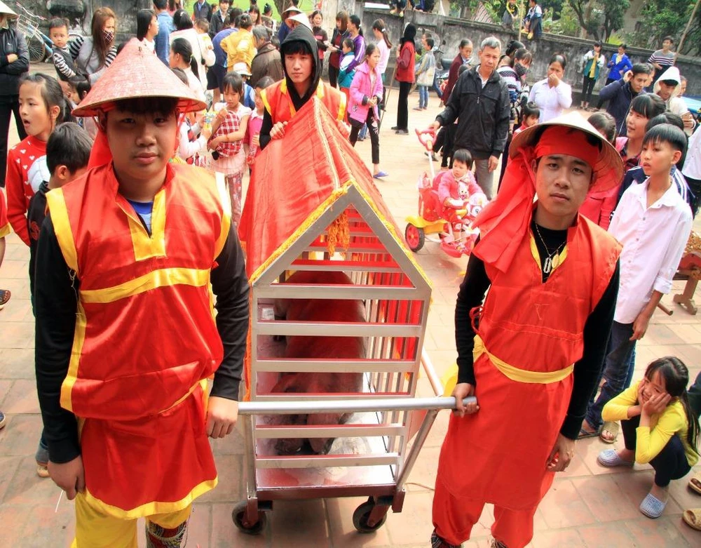 Từ chiều hôm trước, nghi thức tiến hành rước kiệu, rước lợn