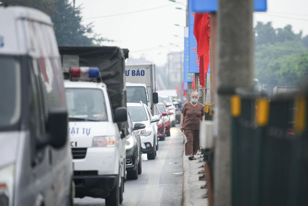 Người đi bộ cũng len lỏi bên cạnh hàng phương tiện chật cứng.