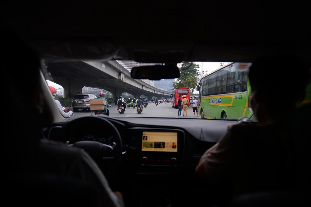 Tuyến đường Phạm Hùng đoạn gần Bến xe khách Mỹ Đình (Hà Nội) có nhiều ô tô dừng đỗ để đón khách, vận chuyển hàng hóa và các nhà xe sử dụng cả “cò” để thông báo khi có lực lượng CSGT, khiến công tác xử lý vi phạm gặp nhiều khó khăn.