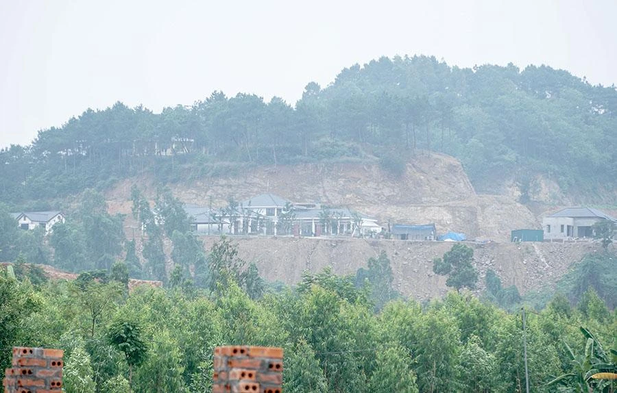 Xung quanh khu vực sạt lở, núi đồi bị đục đẽo, nhà kiên cố mọc lên như "nấm". Ảnh: PHI HÙNG