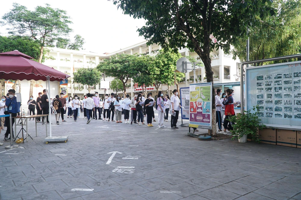 Các thí sinh xếp hàng cất đồ dùng không cần thiết vào thùng giấy. Năm nay vật dụng của thí sinh phải cất với khoảng cách tối thiểu là 25 m so với phòng thi để tránh gian lận thi cử.