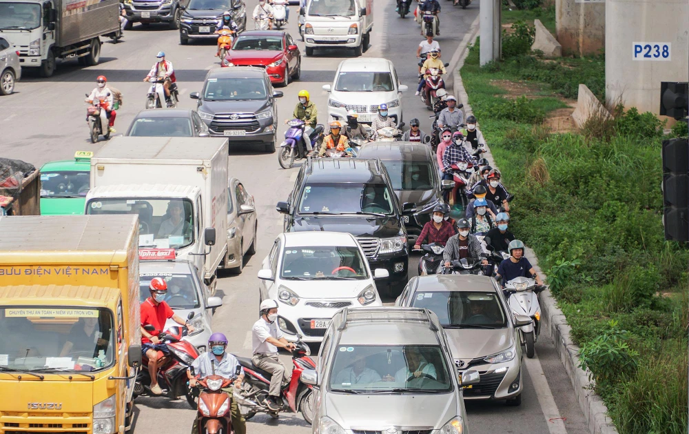Trong lúc chờ đèn đỏ, dưới thời tiết nắng nóng như thiêu đốt, nhiều người đi đường có len lỏi vào nơi bóng mát, dưới chân công trình đường sắt Nhổ - ga Hà Nội.