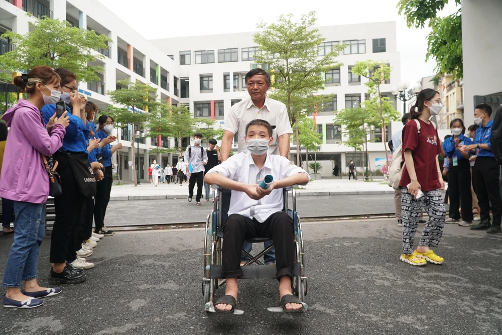 Anh Mạnh cùng con trai mình bức ra khỏi điểm thi sau khi kết thúc môn thi tổ hợp sáng này. Ảnh PHI HÙNG.