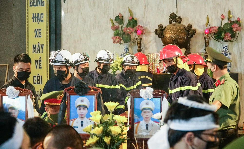 Các đồng chí, đồng đội... hỗ trợ gia đình đưa linh cứu các liệt sĩ ra phía bên ngoài.