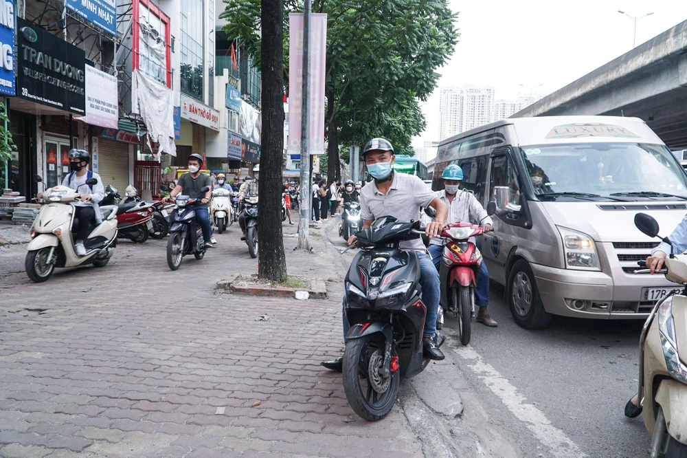 Nhiều người leo cả lên vỉa hè để mong muốn cho mình có lối đi, thoát khỏi cảnh ùn tắc kéo dài hàng giờ.