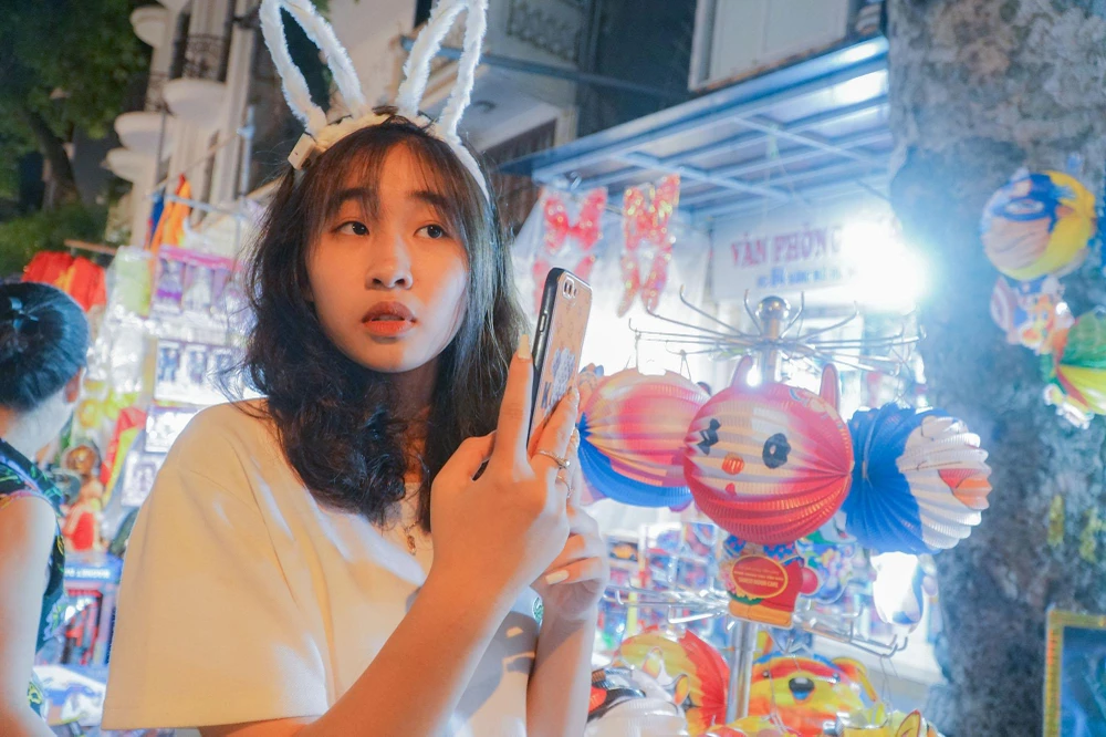 Không chỉ có trẻ nhỏ, nhiều thanh niên cũng mải mê tạo dáng trên phố ngập tràn sắc màu.