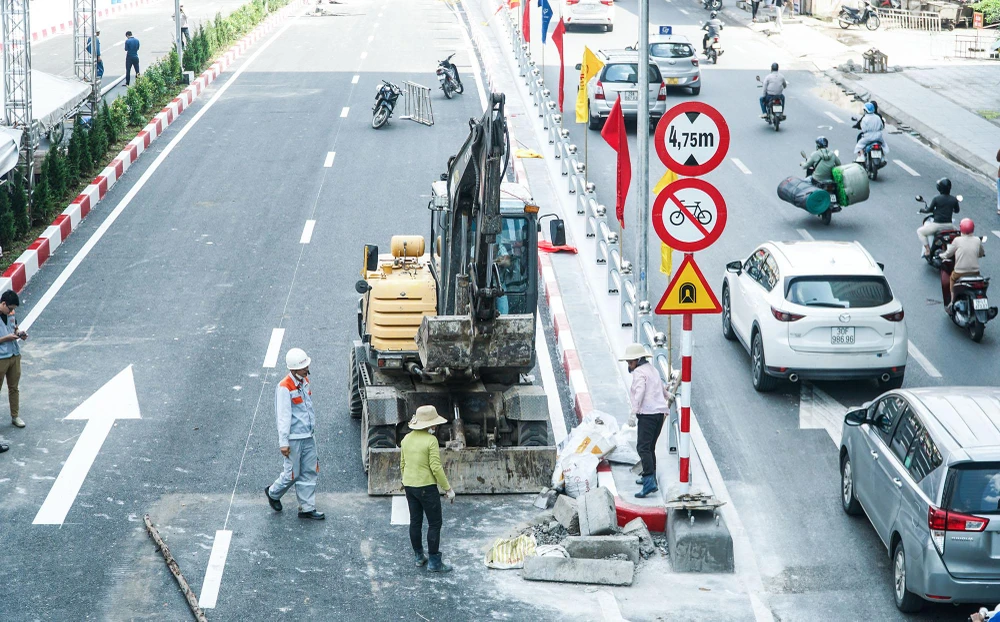 Công nhân đang dọn dẹp những phế liệu ở lối rẽ vào hầm chui.