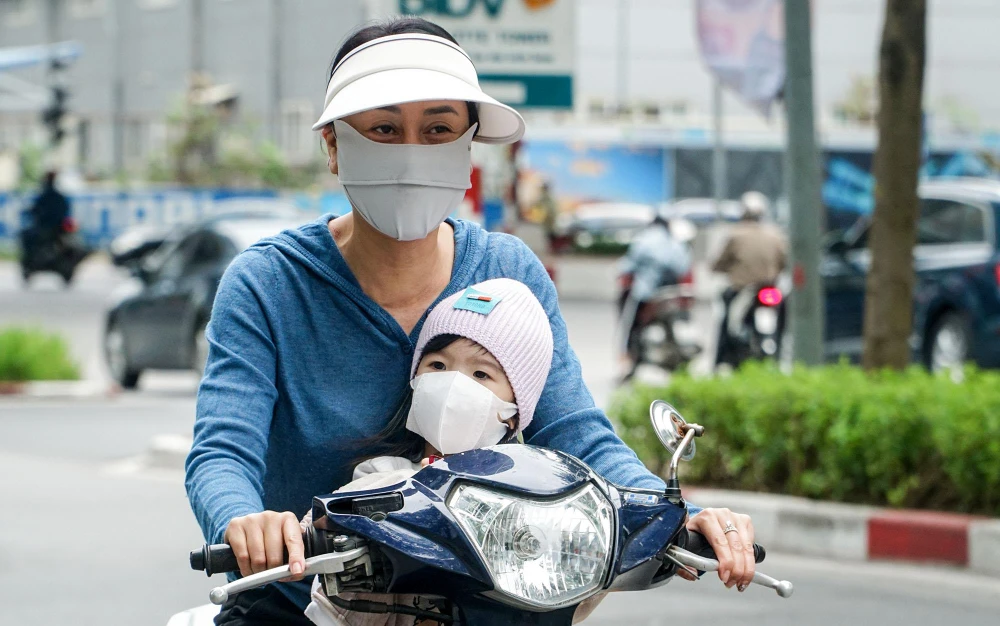 Trên phố Đào Tấn, một em bé được người lới đội mũ len để giữ ấm cho cơ thể. Trung tâm Dự báo Khí tượng Thủy văn quốc gia cho biết, gió mùa đông bắc gây gió mạnh cấp 3, vùng ven biển cấp 4-5.