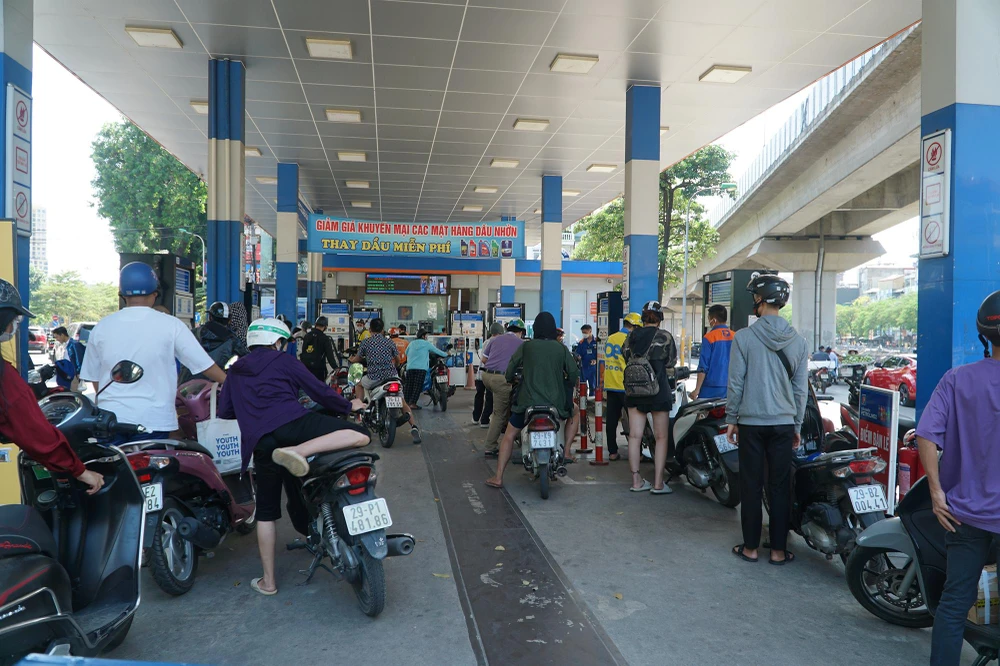 Cây xăng gần ngã tư Sở là một điểm bán lẻ xăng dầu lớn trên đường Láng - vành đai 2 của Hà Nội. Thời điểm ghi nhận trưa 31-10, khách đi xe máy vào mua xăng khá đông.