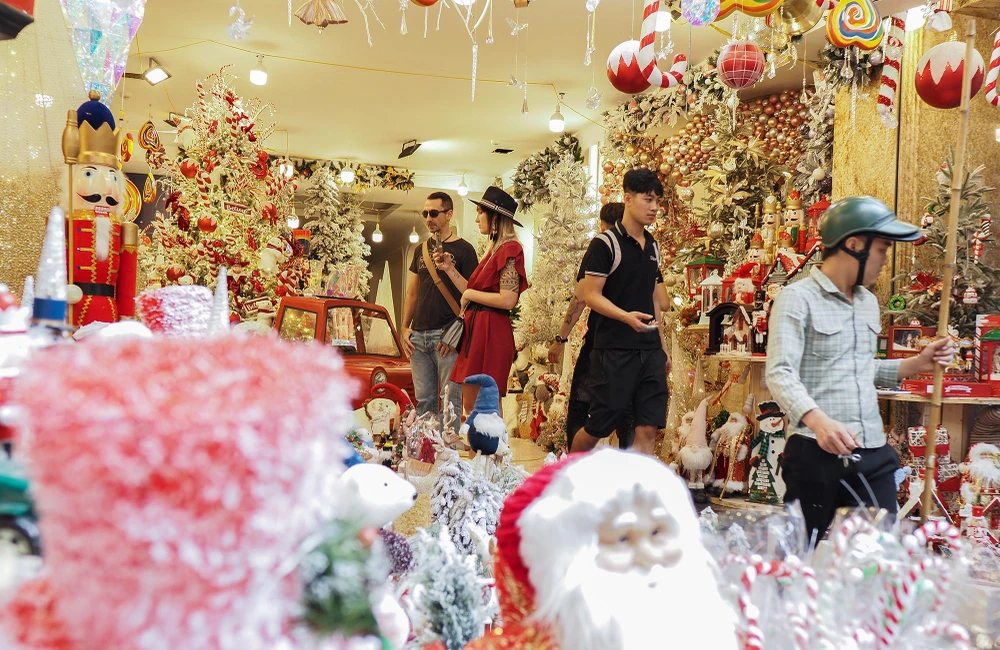 Những cây thông trang trí đèn màu rực rỡ, ông già Noel đứng nhún nhảy trước cửa hàng... đã làm cho con phố Hàng Mã trở nên nhộn nhịp và đông đúc.