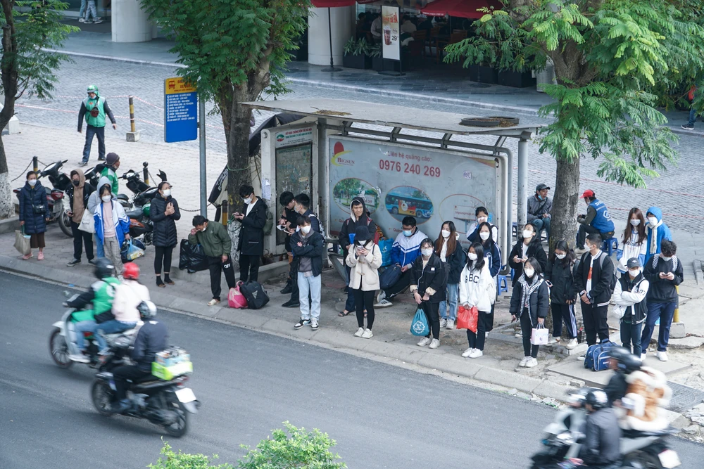 Tại điểm xe buýt nằm trên đường Xuân Thủy, nhiều bạn sinh viên lỉnh kỉnh đồ đạc chờ xe tới để về quê.