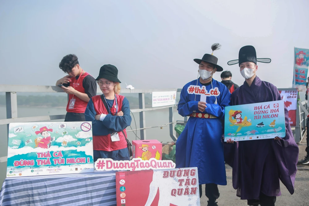 Trên cầu Long Biên, rất đông lực lượng tình nguyện đã đến từ sớm để hỗ trợ người dân thả cá chép xuống sông Hồng.