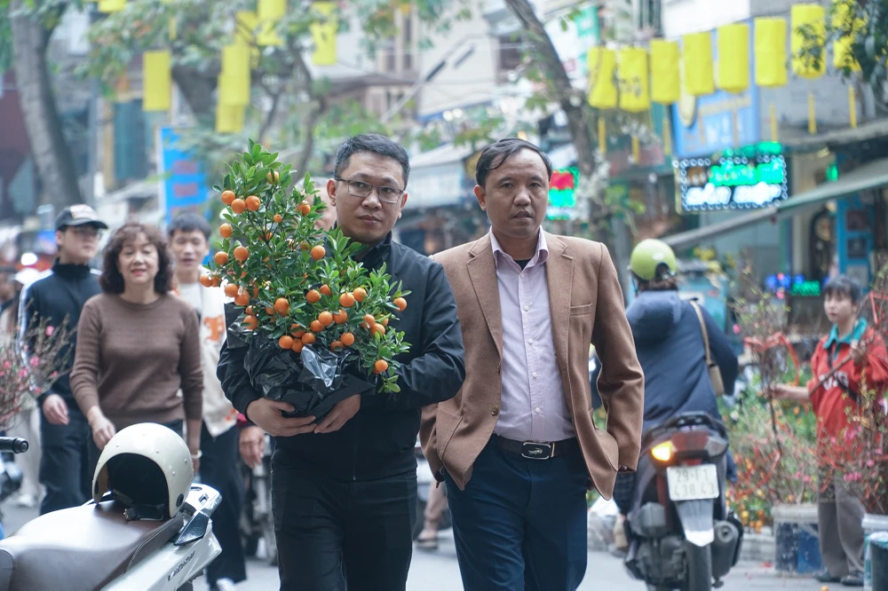 Những ngày cận Tết, người dân Hà Nội lại rộn ràng đi chợ hoa Tết, chọn cho mình những bông hoa tươi thắm nhất, những cành đào đầy nụ và những chậu quất xen lộc xanh non về bày trong nhà.