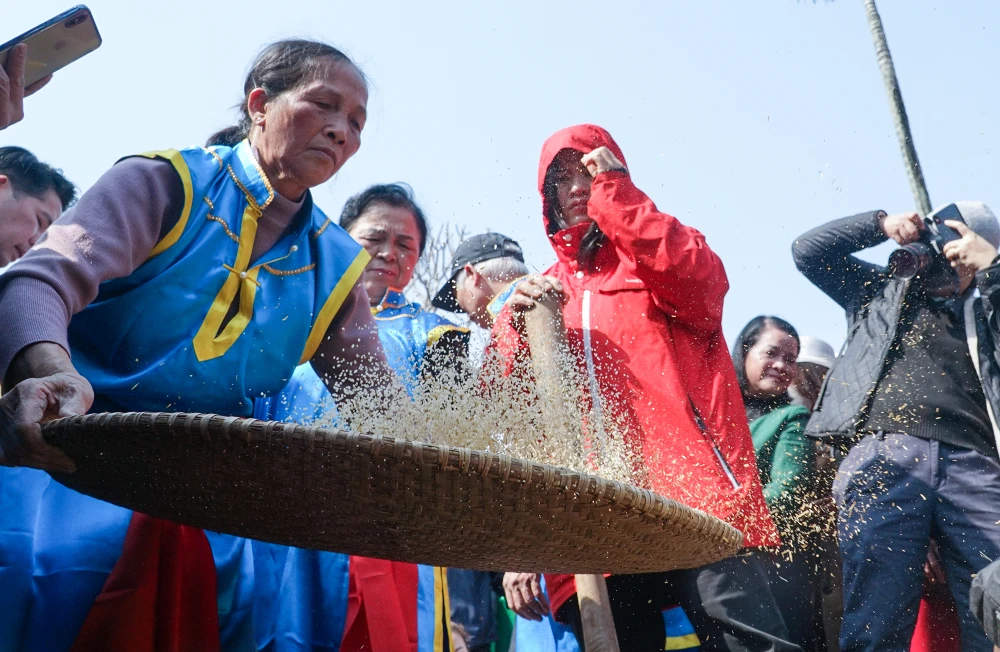 Sau khi giã xong, gạo sẽ được đổ ra, một người dần sàng cho sạch trấu cám và thổi cơm.