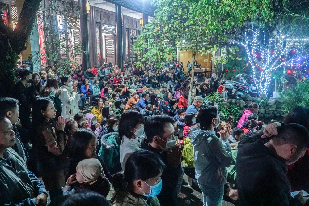 Khắp khuôn viên nhà chùa, từ trong ra ngoài, người dân đứng chen chúc nhưng rất yên lặng khi sư thầy đọc kinh cầu an.