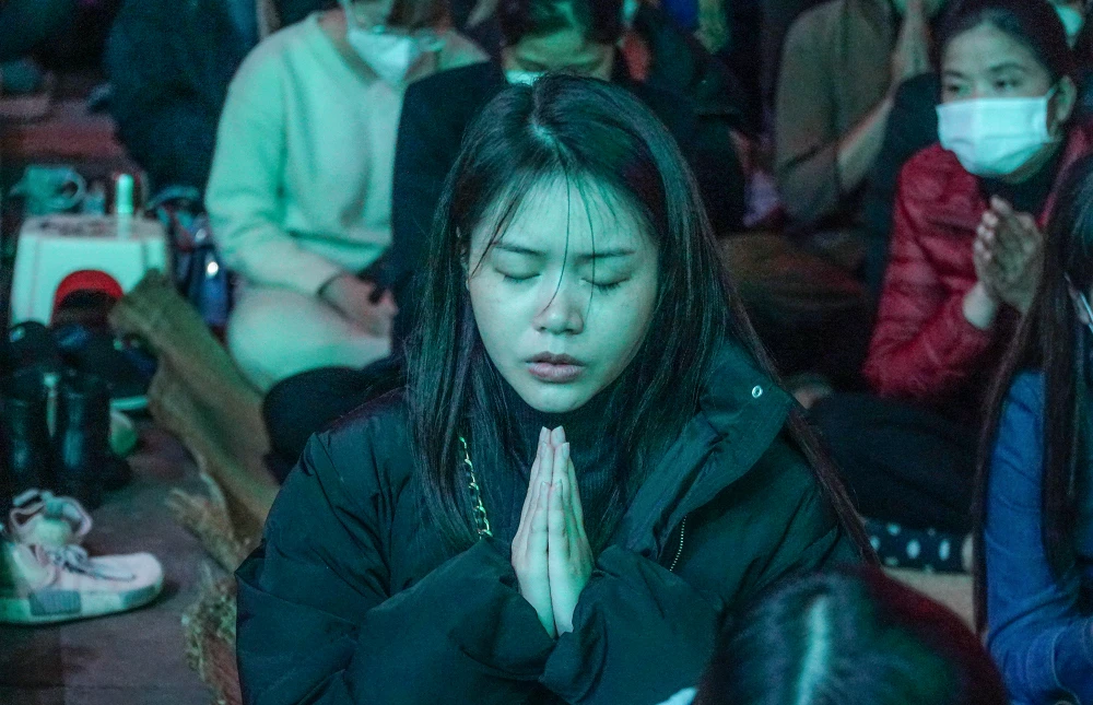 Một cô gái đang cầu an trong đêm.