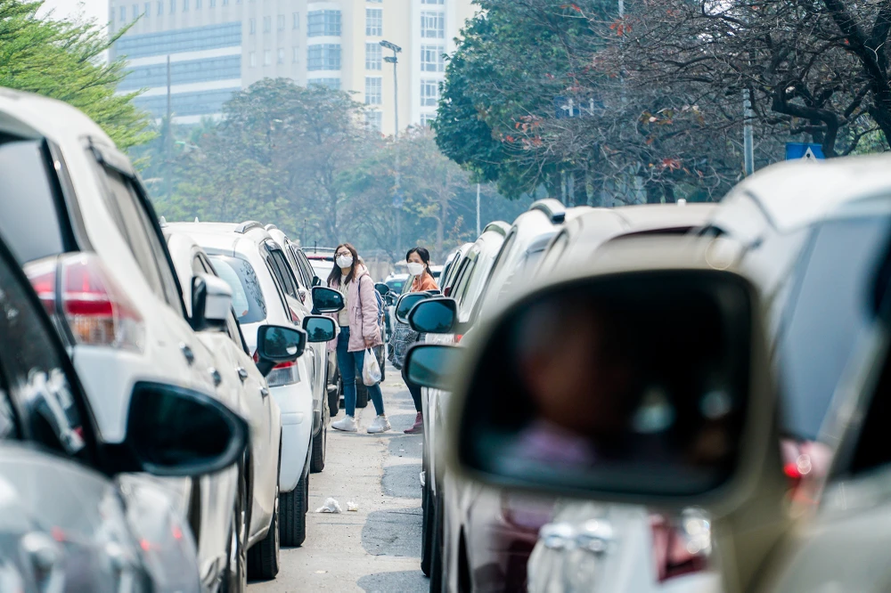 Nhiều người phải len lỏi vào các hàng phương tiện để đứng xuống lòng đường chờ đợi xe buýt.