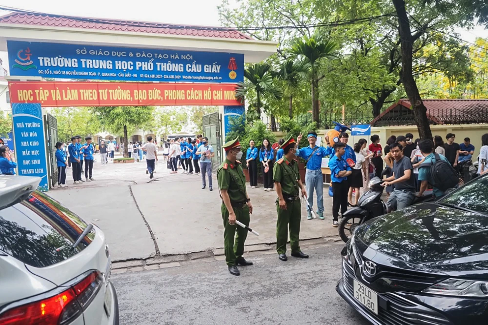 Bên ngoài các điểm thi, công an, bảo vệ và các tình nguyện viên sẽ hướng dẫn, phân luồng học sinh và phụ huynh. Các thí sinh được hướng dẫn đi lên phòng thi kiểm tra thông tin cá nhân, nghe cán bộ coi thi dặn dò. Ảnh: PHI HÙNG