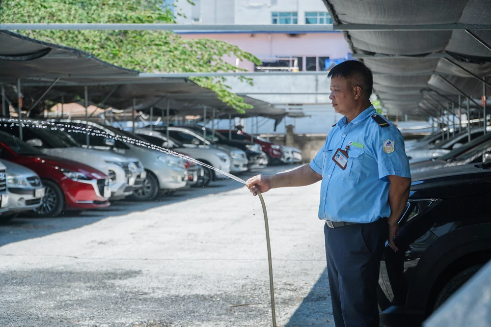Tại một lán trông giữ xe, người bảo vệ liên tục phun nước làm mát xung quanh khu vực, đề phòng hiện tượng cháy nổ có thể xảy đến bất cứ lúc nào.