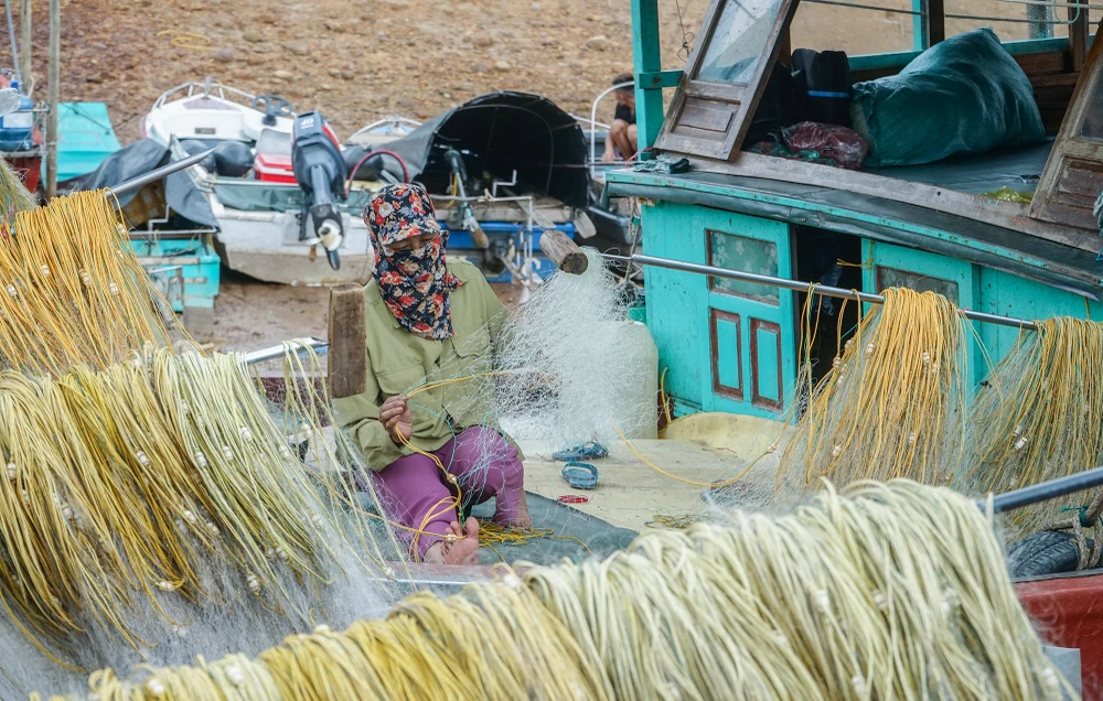 Bà Bùi Thị Nga (52 tuổi) cho biết bà đang chuẩn vá lại lưới đánh cá để bà cùng gia đình sẽ ra khơi đợt đầu tiên sau cơn bão số 1.
