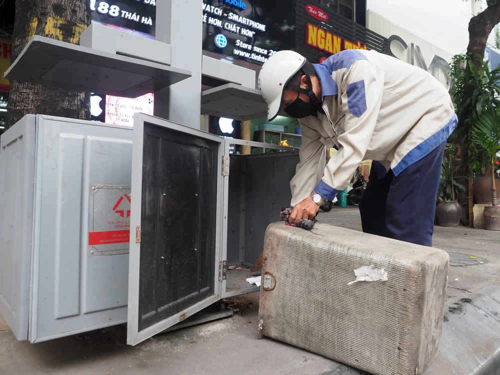 Công nhân đi duy tu, làm vệ sinh thùng rác công nghệ. Ảnh Văn Nam