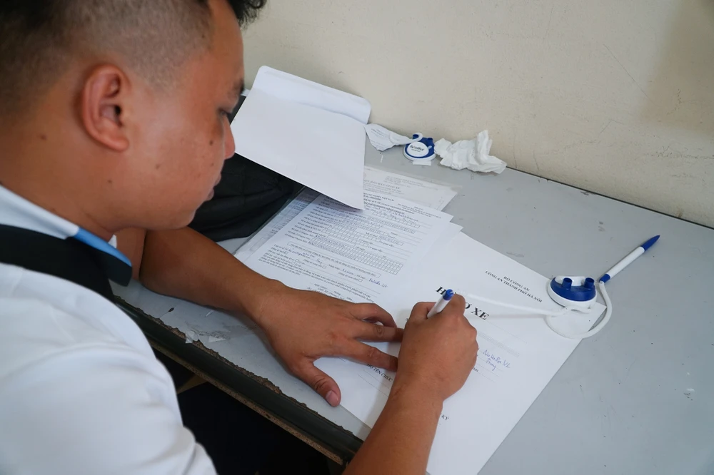 Người dân khai các thông tin cần thiết trong hồ sơ xe khi làm thủ tục.