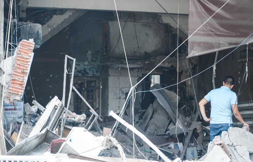 Tầng một của ngôi nhà bị biến dạng, đồ vật, tường xây ngổn ngang.