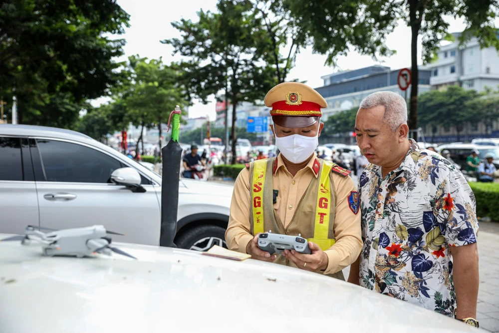 CSGT dừng phương tiện, cho tài xế xem hình ảnh vi phạm.