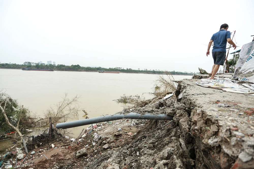 Sạt lở nghiêm trọng, đất đá đổ thẳng xuống sông Hồng để lộ những ống nước sinh hoạt lộ thiên.