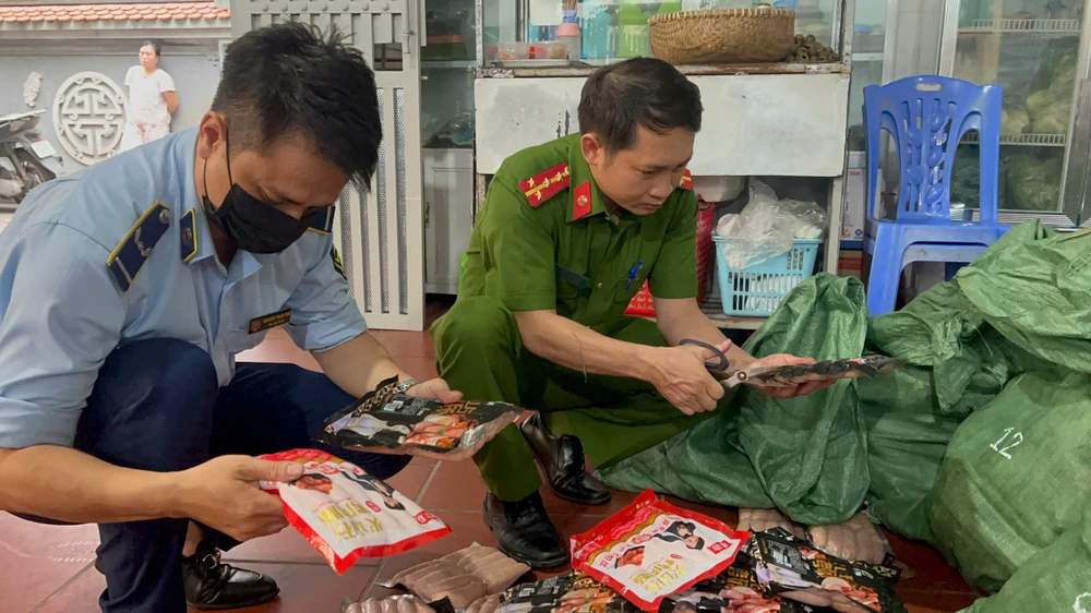 Thời điểm lực lượng chức năng kiểm tra, phát hiện số hàng gần 1 tấn xúc xích không, lạp xưởng không có hóa đơn, chứng từ. Ảnh CA