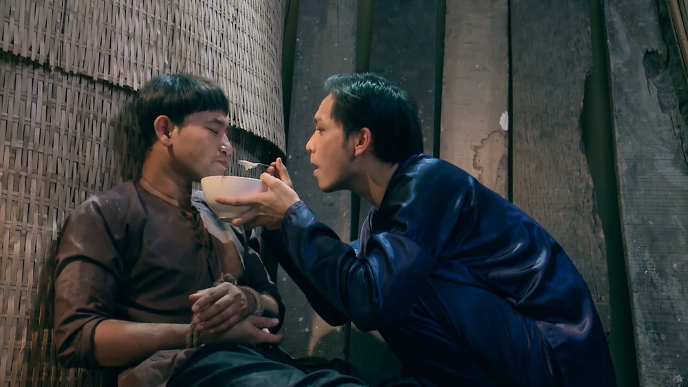 Thành được Hai Lương đút cháo cho ăn.