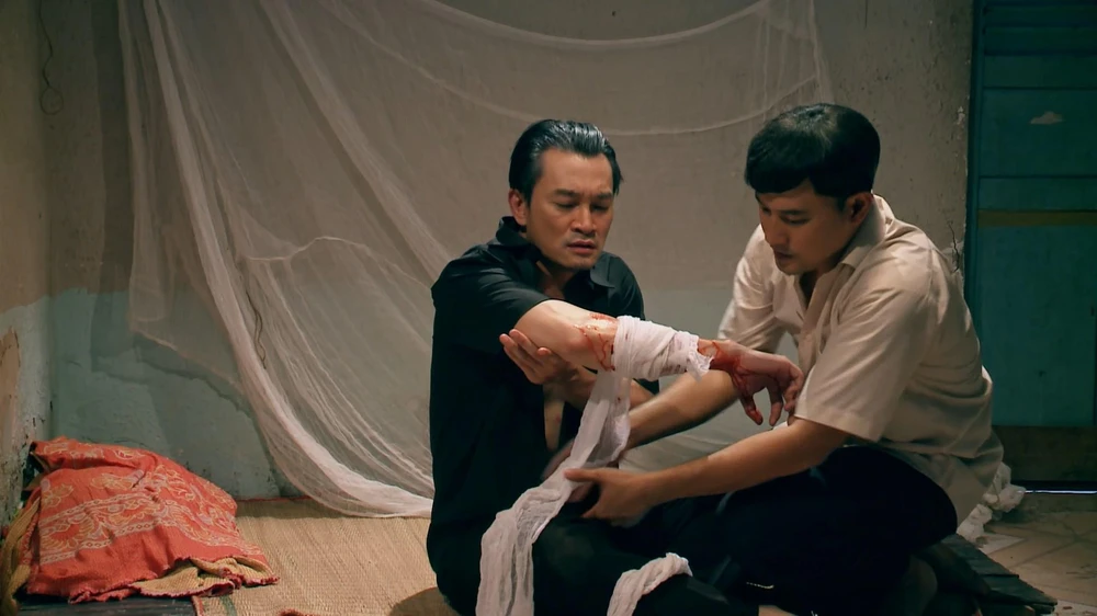 Thành băng bó vết thương cho Hai Thiện.