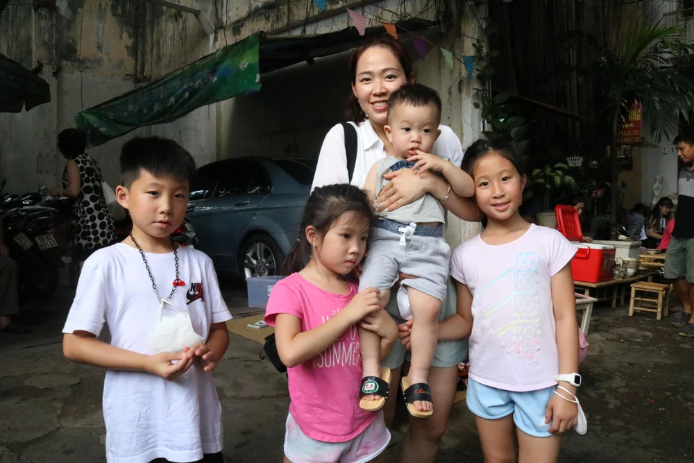 Gia đình chị Trịnh Anh Thư chụp cùng với đôi guốc chị mới vẽ cho con trai. "Hình ảnh đôi guốc gỗ gắn bó với nhiều kỷ niệm về tuổi thơ của tôi. Dịp tết hay trung thu ở Canada tôi sẽ mang áo dài, tôi mua guốc cho con diện chung. Các con tôi rất thích vẽ nên tôi quyết định chọn hình cho con. Trên đôi guốc có hình con thích, nó vừa truyền thống mà nó vừa hiện đại” - chị Thư chia sẻ.