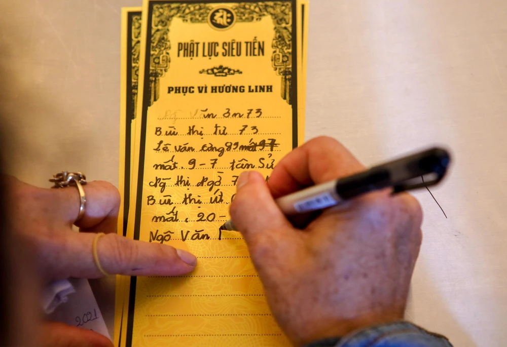 Nhiều gia đình viết thông tin người thân để nhờ các chư tăng cầu siêu.