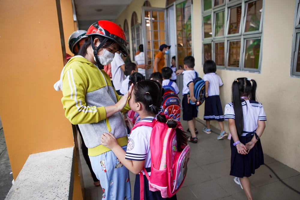 Trong ngày đầu đến trường, các em học sinh lớp 1 bịn rịn chia tay cha mẹ. "Sáng nay bé đi học còn khá rụt rè, ngày đầu đến trường có lẽ nhiều bỡ ngỡ với con, hy vọng những ngày tới con sẽ hòa nhập thật tốt" - chị Thu Quỳnh (phụ huynh) chia sẻ.