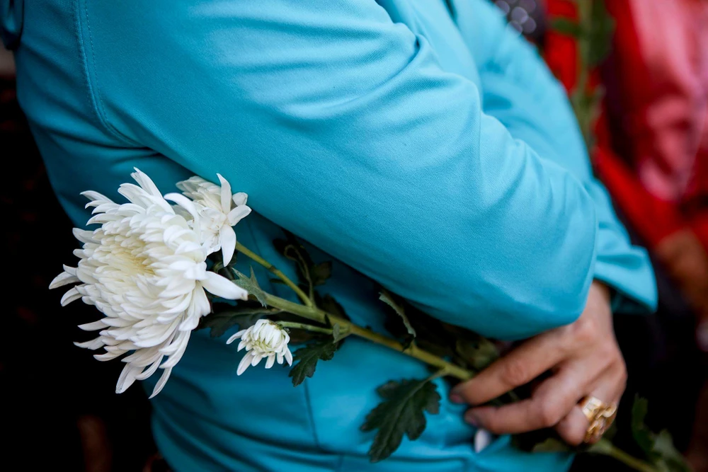 Những đóa hoa cúc trắng được người dân mang đến trước cổng tòa án để tưởng niệm V.A.