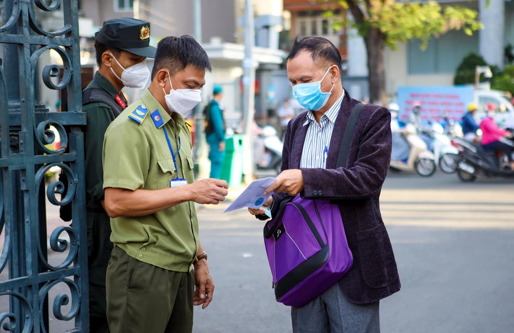 Người dân trình cho lực lượng an ninh giấy triệu tập phiên tòa.