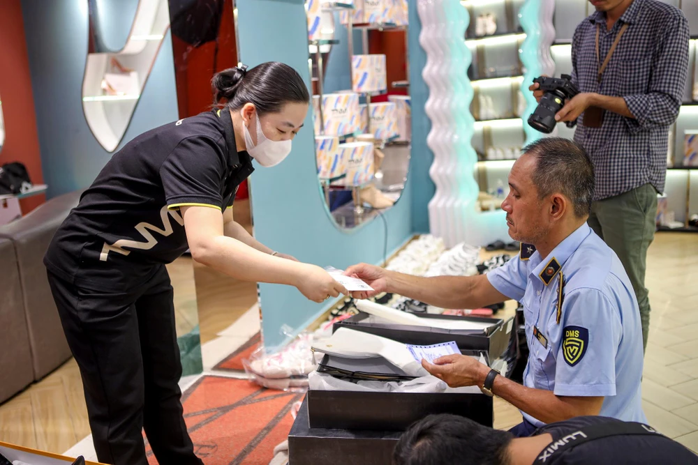 Nhân viên cửa hàng phối hợp với quản lý thị trường trong ngày làm việc.