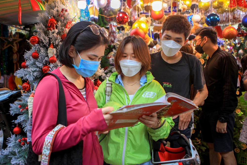 Khách hàng xem bảng giá để chọn cho mình những cây thông phù hợp.