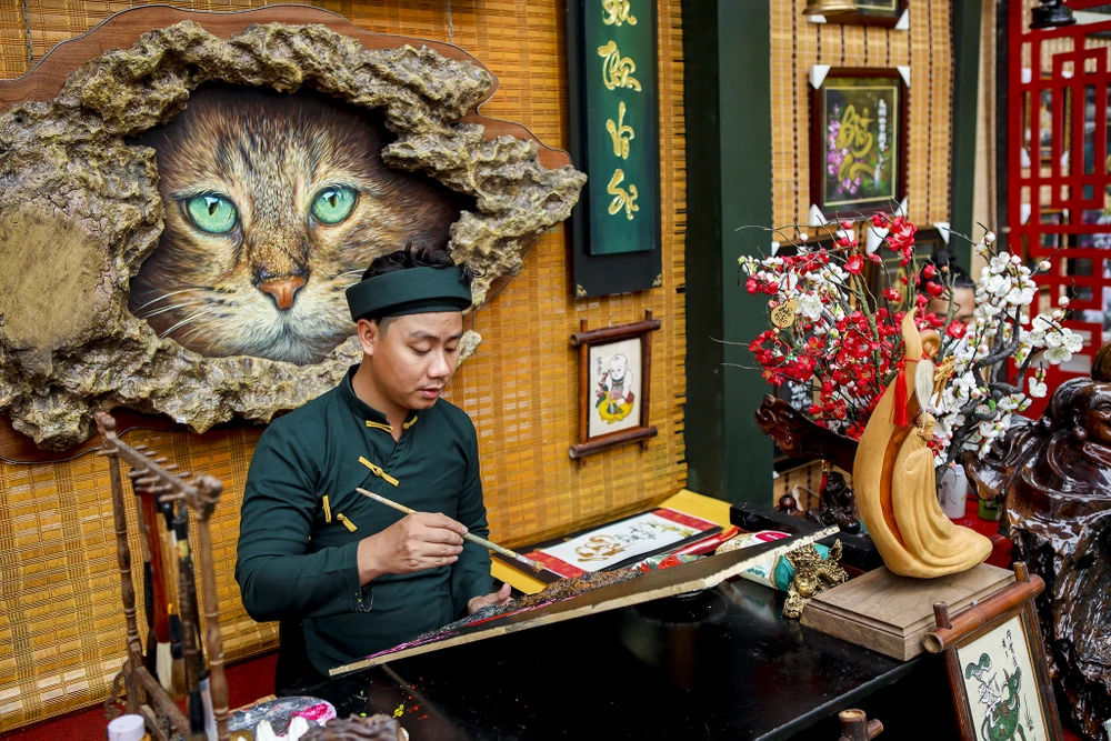 Nhiều ông đồ diện áo dài, khăn đóng để viết chữ, vẽ tranh cho khách. Ngoài chữ thư pháp, các sản phẩm là bao lì xì, tranh sơn mài cũng là mặt hàng hút khách tại đây.